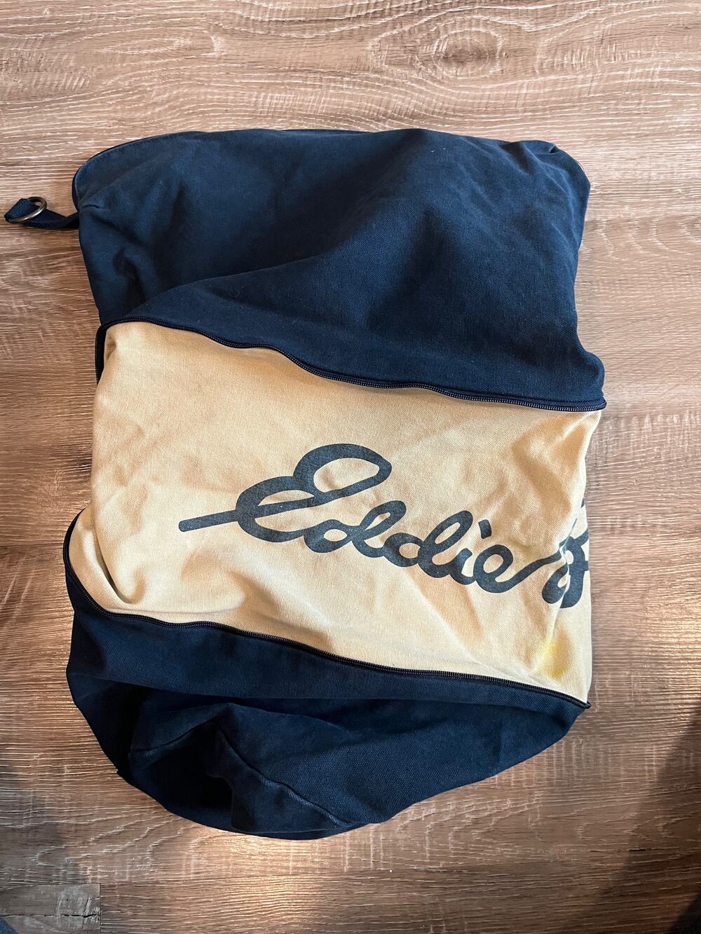 Eddie Bauer navy canvas duffel bag with beige logo panel and zipper compartments